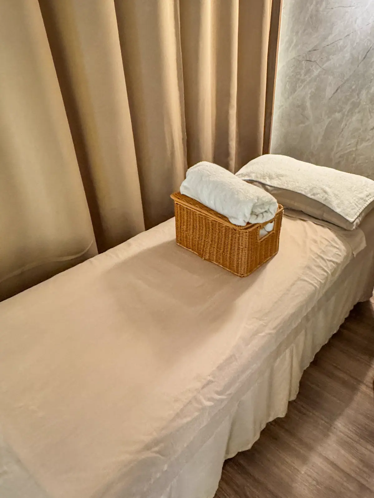 Massage bed with rolled towel and rattan basket